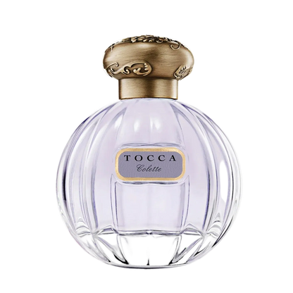 Tocca perfume bottle with gold cap on a light gray background